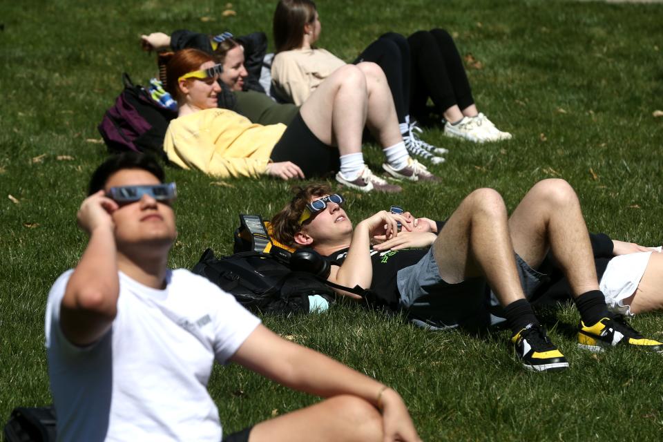 People gather to watch a partial solar eclipse Monday, April 8, 2024 at the Pentacrest in downtown Iowa City, Iowa.