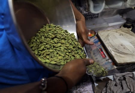 A shopkeeper packs cardamom for a customer in a market area in the old quarters of Delhi