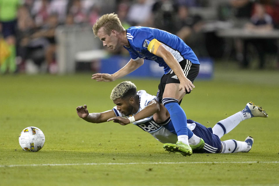 Vancouver Whitecaps midfielder Pedro Vite (45) is tripped from behind by San Jose Earthquakes midfielder Jackson Yueill (14) during the second half of an MLS soccer match in San Jose, Calif., Sunday, Sept. 4, 2022. San Jose won 2-0. (AP Photo/Tony Avelar)