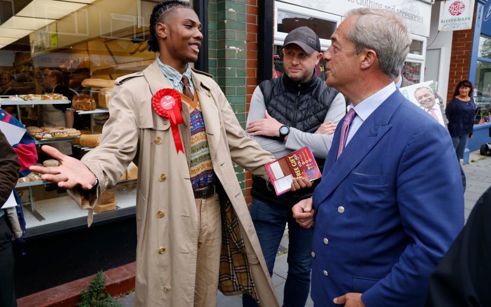 Nigel Farage (right) meets Labour candidate Jason Owusu-Nepaul during a walkabout on the campaign trail