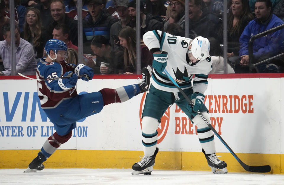 Colorado Avalanche right wing Logan O'Connor, left, loses his balance as San Jose Sharks left wing Evgeny Svechnikov collects the puck in the third period of an NHL hockey game Tuesday, March 7, 2023, in Denver. (AP Photo/David Zalubowski)