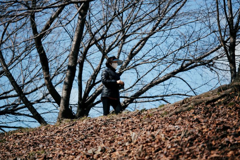 A woman wearing a mask to prevent contracting the coronavirus walks at a park in Seoul