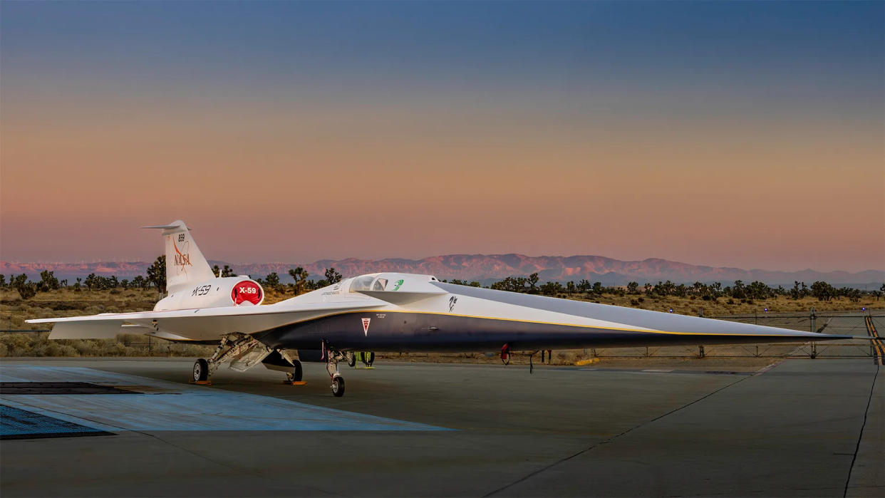  A sleek white and blue supersonic jet on the tarmac. 