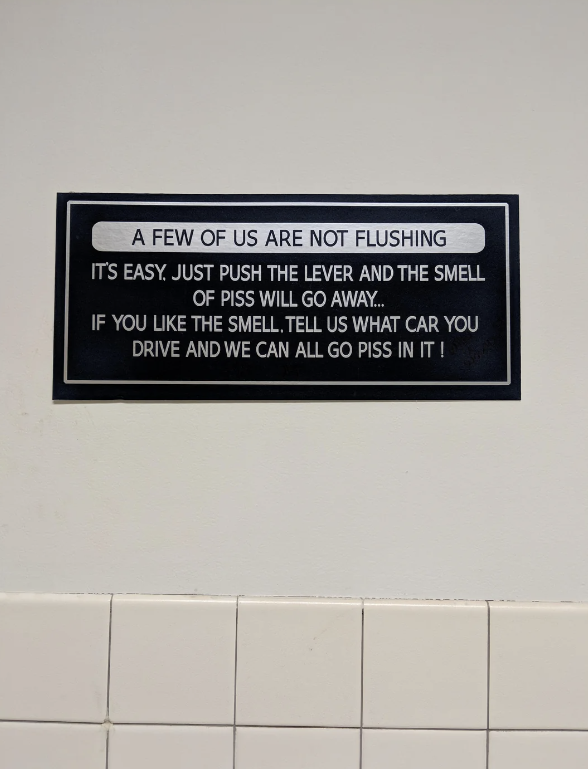 A humorous bathroom sign reads: "A few of us are not flushing. It's easy. Just push the lever and the smell of piss will go away... If you like the smell, tell us what car you drive and we can all go piss in it!"