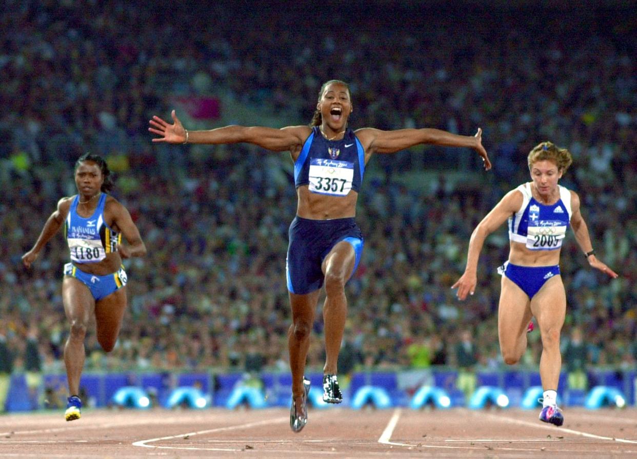 Marion Jones of the US (3357) exults as she crosses the finish line to win the final of the women's 100m on 23 September, 2000