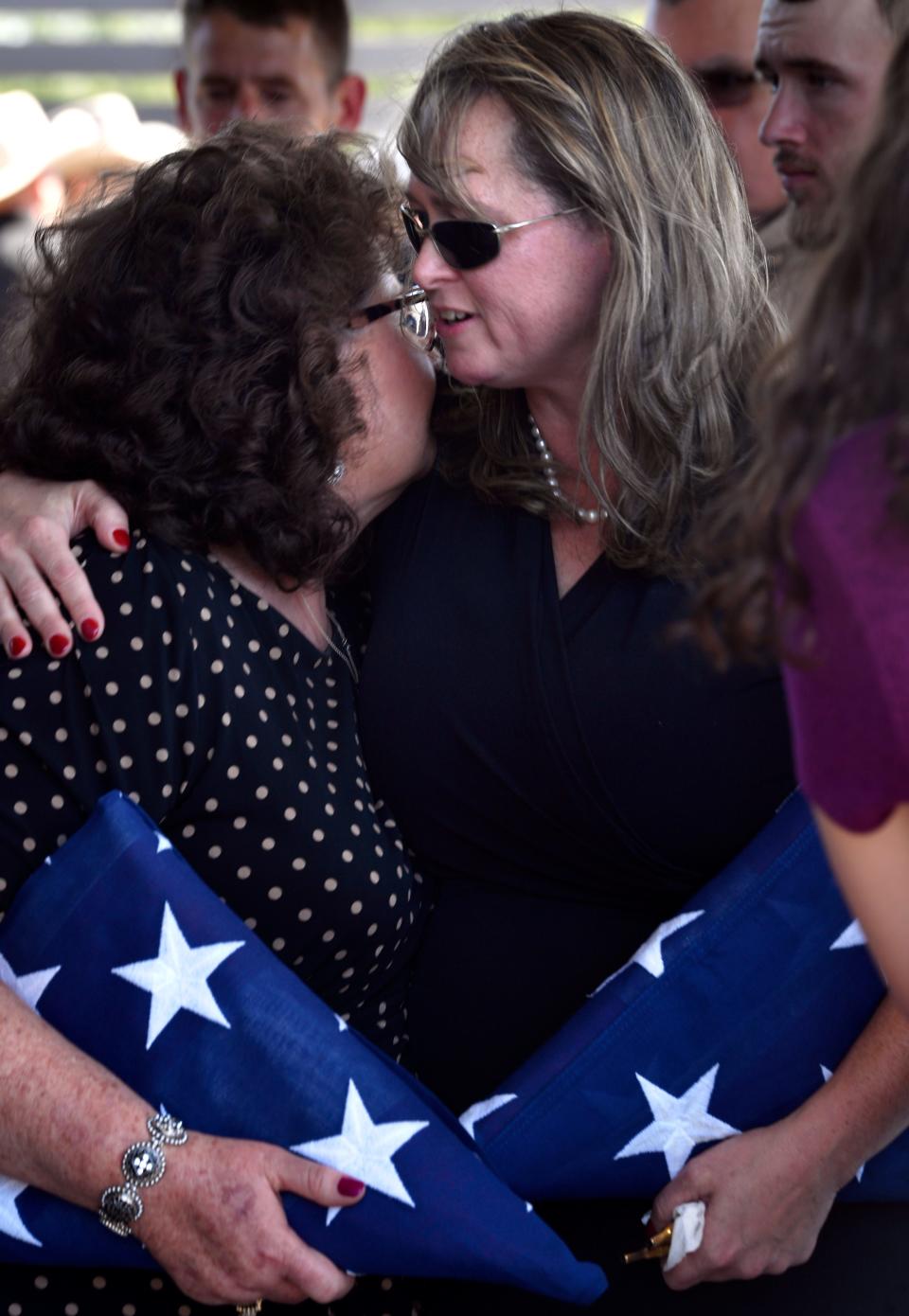 Sandra Smith (left), the mother of Austin police officer Anthony Martin, and, his wife, Amberlee Martin, embrace at the end of his funeral service at the Abilene Texas State Veterans Cemetery Tuesday.