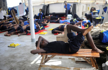 Migrants are seen resting on board of the MV Aquarius rescue ship run by SOS Mediterranee organisation and Doctors Without Borders during a search and rescue (SAR) operation in the Mediterranean Sea, off the Libyan Coast, August 12, 2018. REUTERS/Guglielmo Mangiapane