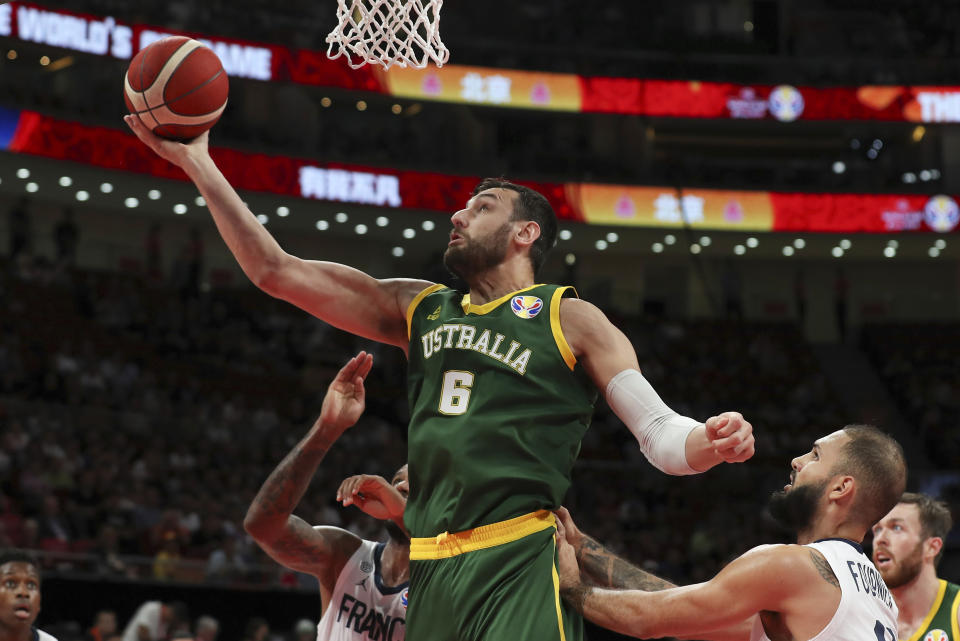 FILE - In this Sept. 15, 2019, file photo, Andrew Bogut of Australia puts up a shot over Amath M'Baye, left, and Evan Fournier of France during their third placing match for the FIBA Basketball World Cup at the Cadillac Arena in Beijing. Bogut announced Tuesday, Dec. 1, 2020 that he is calling quits on his bid for an Olympic medal and has decided to retire after 15 years in professional basketball. (AP Photo/Ng Han Guan, File)