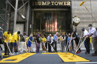 New York Mayor Bill de Blasio, wearing orange mask, participates in painting Black Lives Matter on Fifth Avenue in front of Trump Tower, Thursday, July 9, 2020, in New York. (AP Photo/Mark Lennihan)