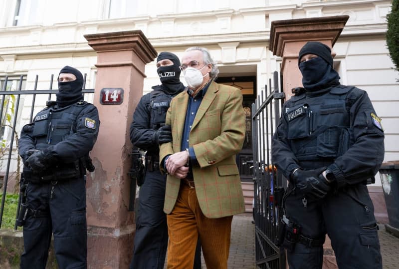 Heinrich XIII (C), who goes under the title Prince Reuss of Greiz, is led by police officers to a police vehicle after arresting him while searching a house as part of a raid aginst so-called "Reich citizens". Boris Roessler/dpa