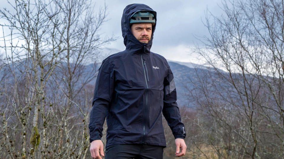 Rapha Trail GORE-TEX Infinium Jacket with the hood worn over  a helmet