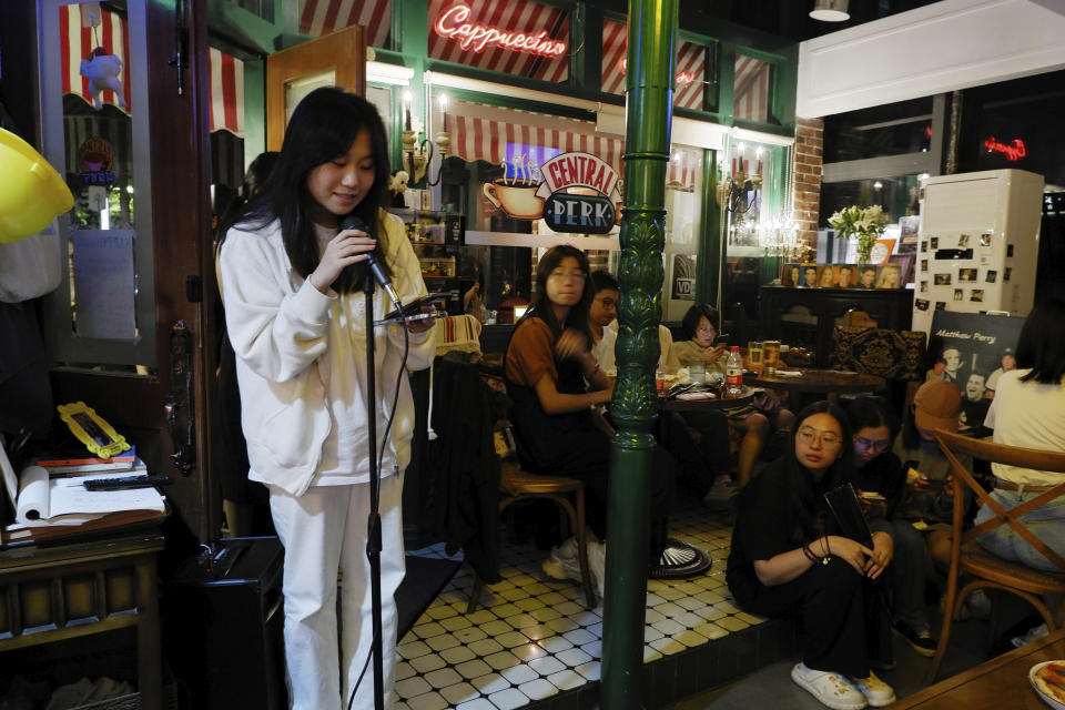 In this photo released by Nie Yanxia, a fan speaks during a memorial for Matthew Perry, the actor who played Chandler in the hit sit-com "Friends," in a cafe styled to look like the setting in the series in Shenzhen in southern China, on Nov. 1, 2023. Long before "Friends" made its official debut in China, the show was a word-of-mouth phenomenon in the country. In the wake of Matthew Perry's death at 54, fans in China are mourning the loss of the star who felt less like a distant celebrity and more like an old friend. (Nie Yanxia via AP)