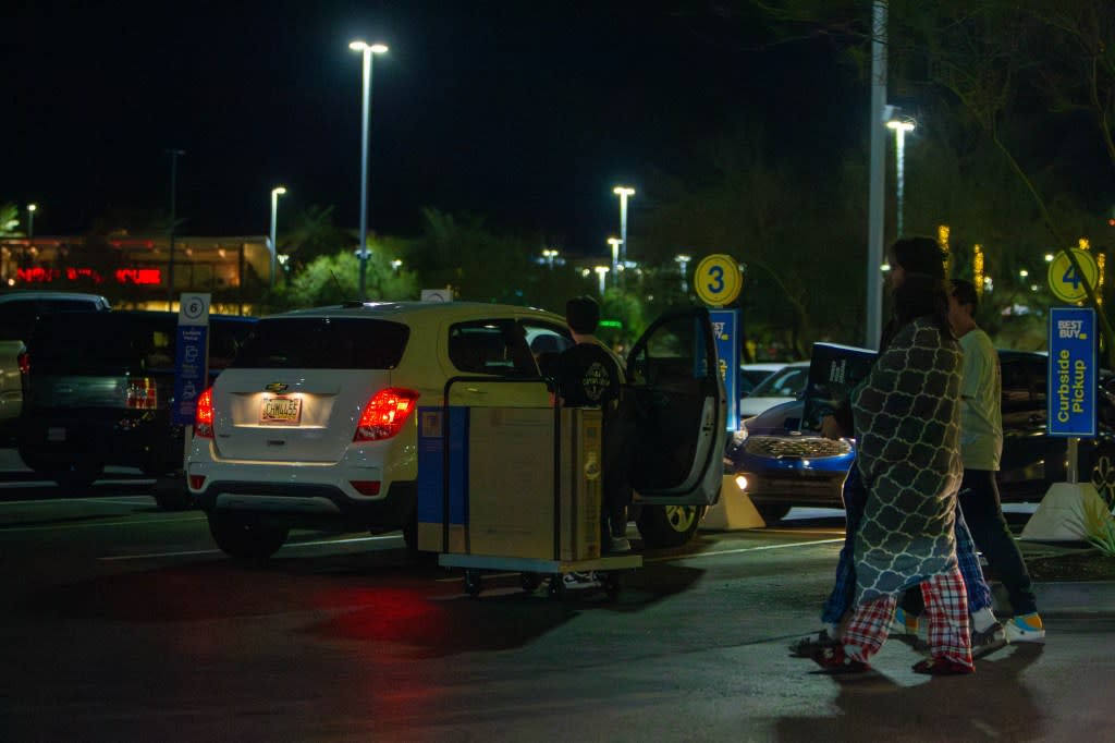 A Best Buy employee helps load a TV into a customer’s car as more Black Friday shoppers walk out with new electronics at Tempe Marketplace on November 24, 2023. (Credit: Sam Ballesteros/The Republic / USA TODAY NETWORK)