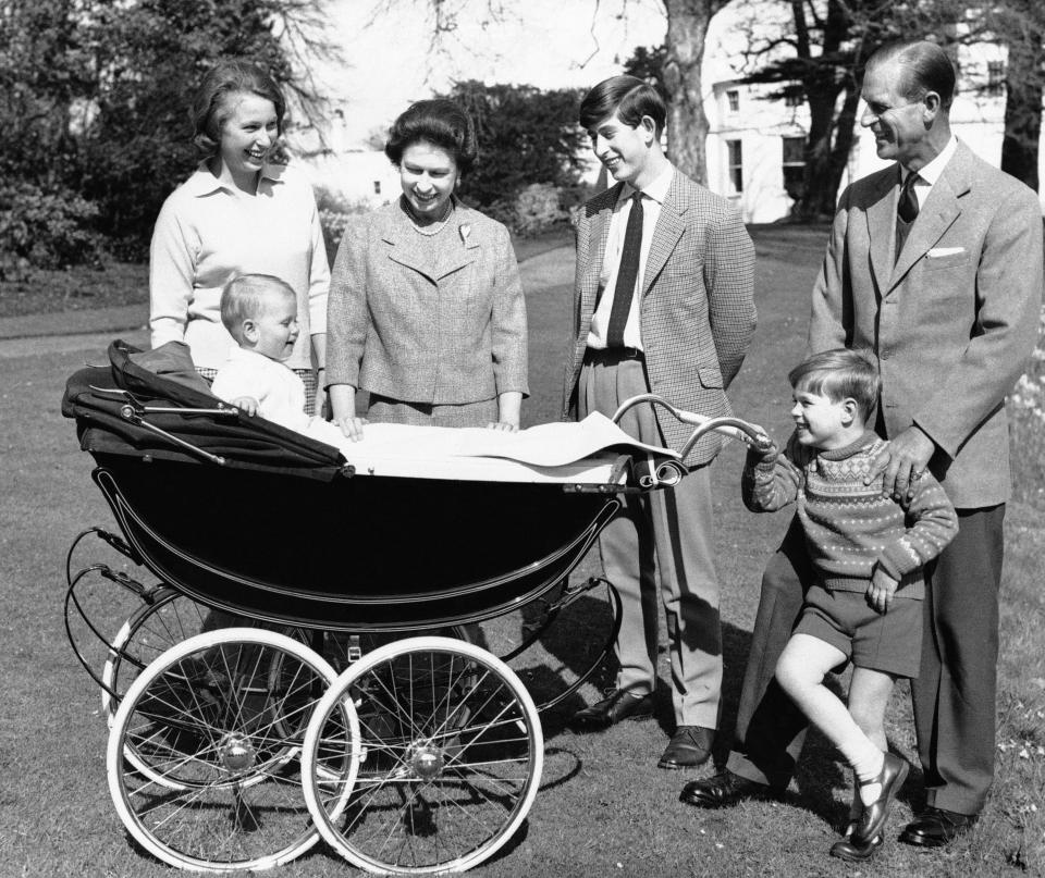 In this Dec. 19, 1965, file photo, Britain's Queen Elizabeth II and Prince Philip are surrounded by members of her family on the grounds of Windsor Castle in Windsor, England. From left, Princess Anne, Prince Charles, Prince Andrew. In the pram is Prince Edward.