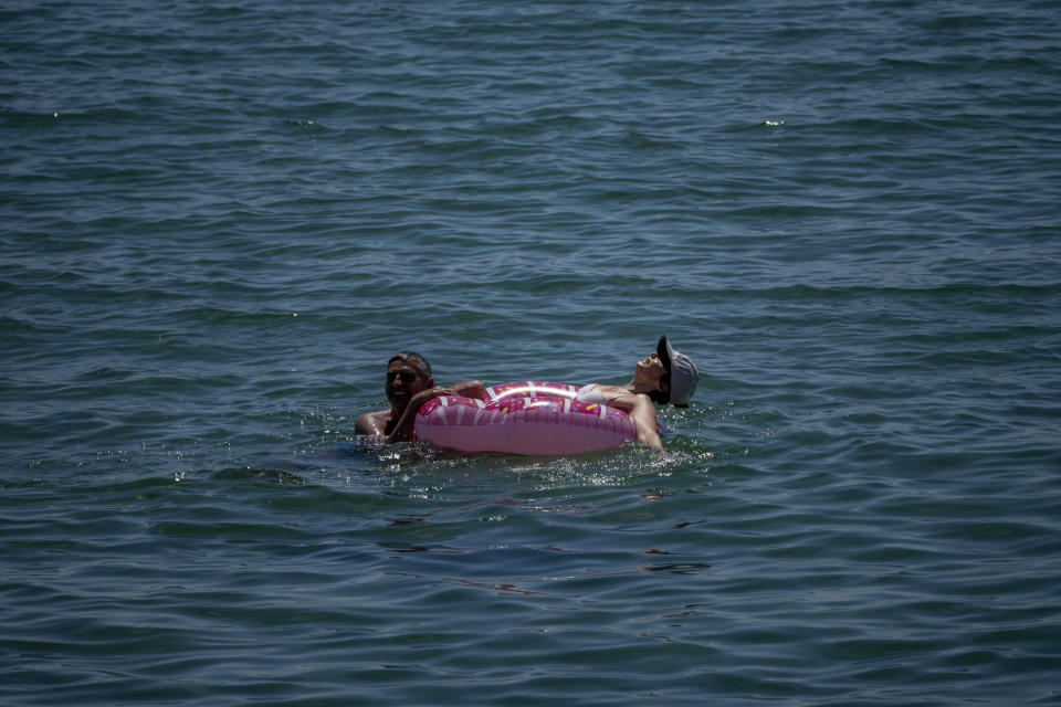 A couple cool off in the sea off the beach in Barcelona, Spain, Tuesday, June 8, 2021. Spain is jumpstarting its summer tourism season by welcoming vaccinated visitors from most countries as well as European visitors who can prove they are not infected with coronavirus. (AP Photo/Emilio Morenatti)