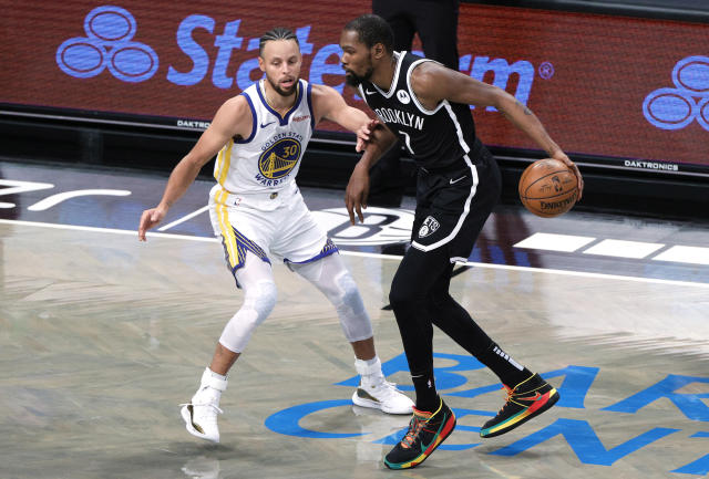 Kevin Durant dribbles against Stephen Curry.