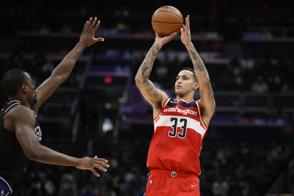 Washington Wizards forward Kyle Kuzma (33) shoots against Sacramento Kings forward Harrison Barnes during the first half of an NBA basketball game Saturday, Feb. 12, 2022, in Washington. (AP Photo/Nick Wass)