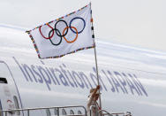 Tokyo governor Yuriko Koike waves the Olympic flag as she walks out of a plane during a ceremony to mark the arrival of the Olympic flag at Haneda airport in Tokyo, Japan, August 24, 2016. REUTERS/Kim Kyung-Hoon