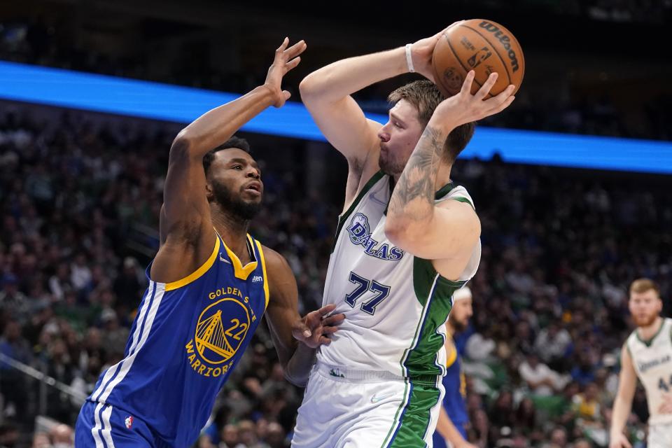 Golden State Warriors forward Andrew Wiggins (22) defends as Dallas Mavericks guard Luka Doncic (77) looks to make a pass in the first half of an NBA basketball game in Dallas, Thursday, March, 3, 2022. (AP Photo/Tony Gutierrez)