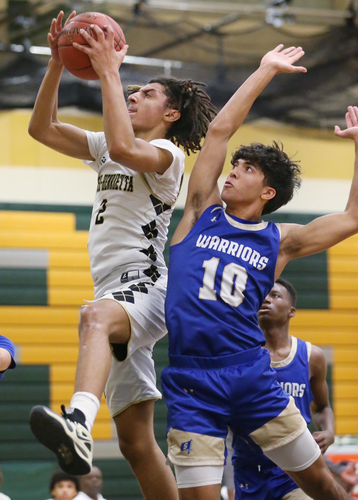 Rush-Henrietta's Graylin Strong pulls down a defensive rebound away from pressure by Webster Schroeder's Jack Kelly in the second quarter during their crossover Section V boys basketball game Wednesday, Dec. 20, 2023 at Rush-Henrietta High School. RH won the tight contest 64-63.