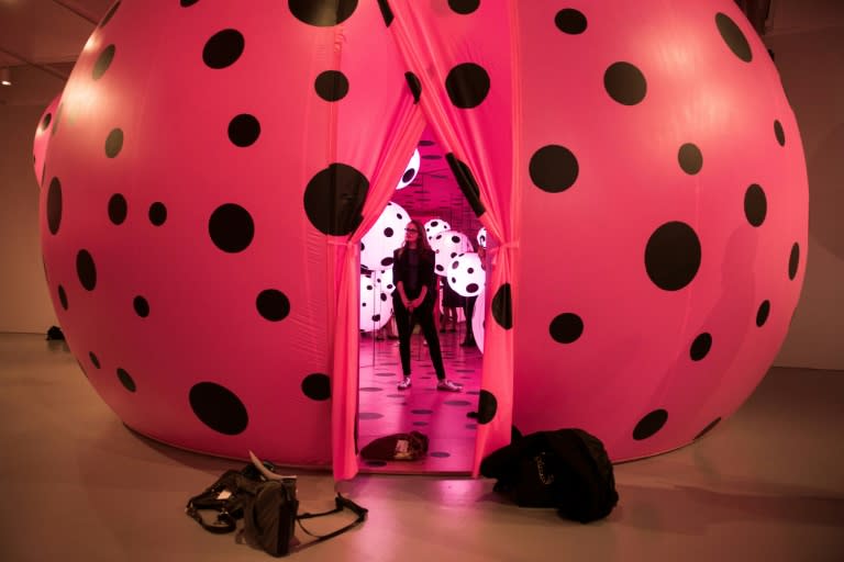 A woman stands in the Dots Obsession, Love Transformed into Dots room during a preview of the Yayoi Kusama's Infinity Mirrors exhibit at the Hirshhorn Museum February 21, 2017 in Washington, DC