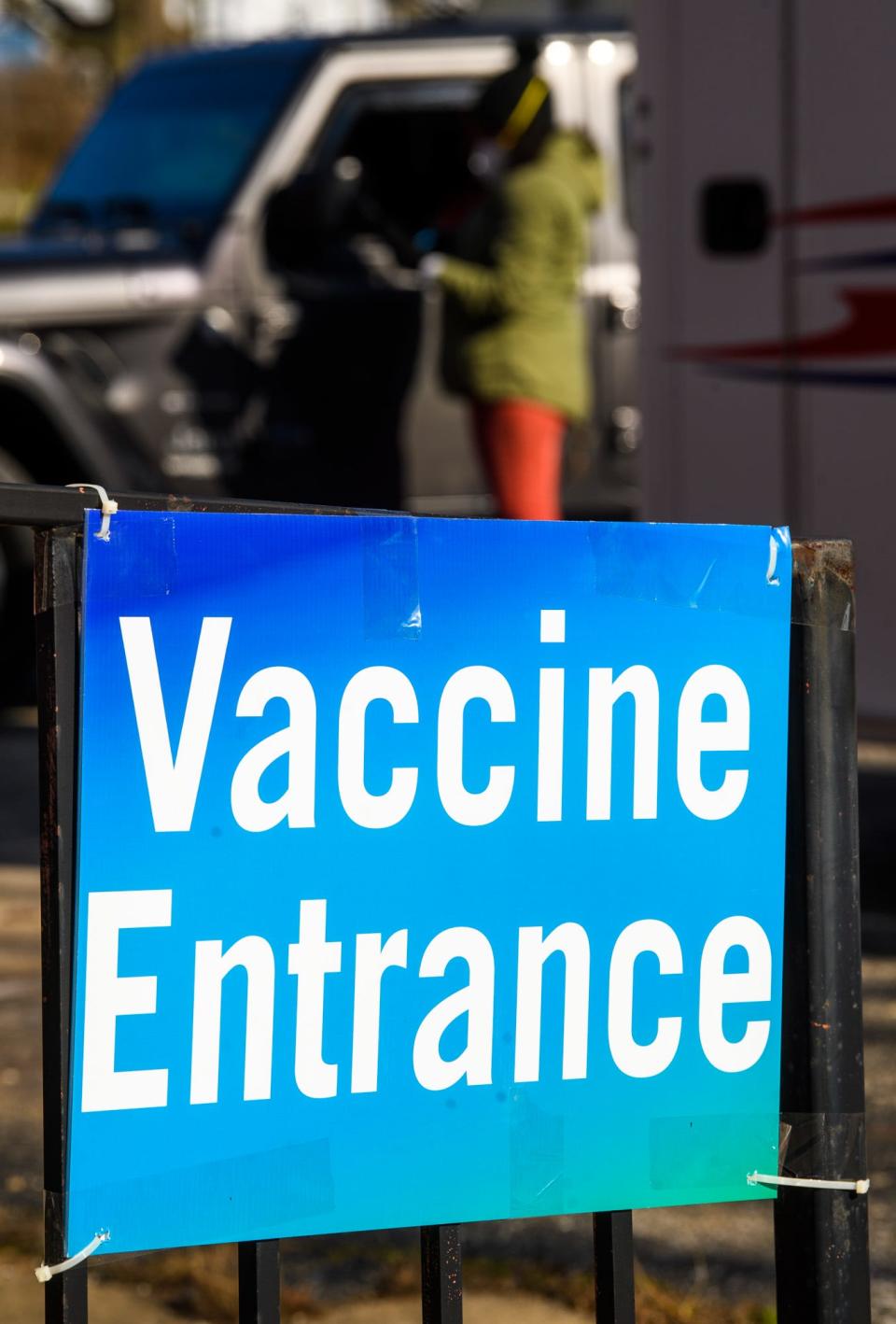 A "Vaccine Entrance" sign is seen outside a COVID-19 vaccination clinic on Indiana Avenue Jan. 5 as a driver pulls up to sign in.