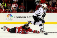 NEWARK, NJ - JUNE 09: Jarret Stoll #28 of the Los Angeles Kings handles the puck as Stephen Gionta #11 of the New Jersey Devils hits the ice during Game Five of the 2012 NHL Stanley Cup Final at the Prudential Center on June 9, 2012 in Newark, New Jersey. (Photo by Elsa/Getty Images)