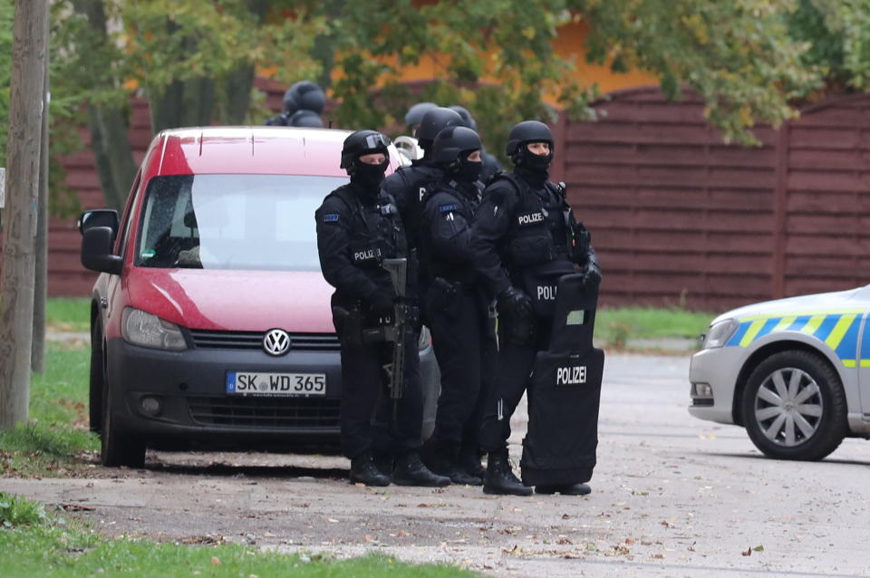 Police officers secure the surrounding of Landsberg, Germany, Wednesday, Oct. 9, 2019. One or more gunmen fired several shots on Wednesday in the German city of Halle. Police say a person has been arrested after a shooting that left two people dead. (Jan Woitas/dpa via AP)