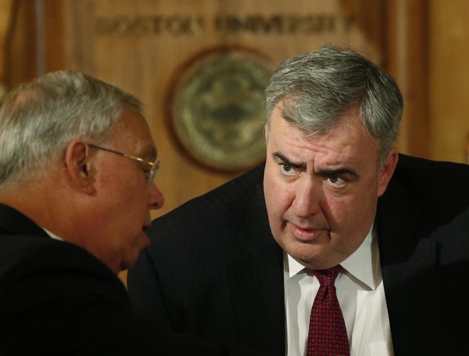 Former Boston Police Commissioner Ed Davis, right, leans in to speak to former Boston Mayor Thomas Menino during a break in a forum entitled, "Leading Cities Through Crisis: Lessons from the Boston Marathon" held at Boston University in Boston, Monday, March 24, 2014. (AP Photo/Elise Amendola)