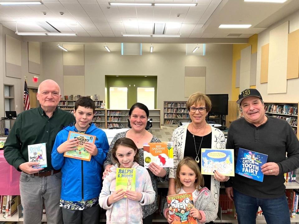 From left, 

Books being given to students at James L. Mulchaey Elementary School in memory of their teacher Maureen Drake are displayed (Left to right) by  her;  husband, Frank Drake, grandson Drake Charbonneau, daughter Janine Charbonneau, granddaughter 
 Hannah Charbonneau ( front) Anne Marie Rodrigues 
( Maureen’s friend) back row)  Ava Letourneau (front a current Mulcahy student and granddaughter of Rodrigues) and  Randy Silveira  ( Maureen’s brother)