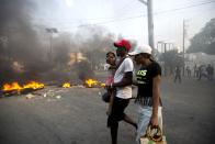 <p>People walk past a barricade during a protest over the cost of fuel in Port-au-Prince, Haiti, Friday, July 6, 2018. (Photo: Dieu Nalio Chery/AP) </p>