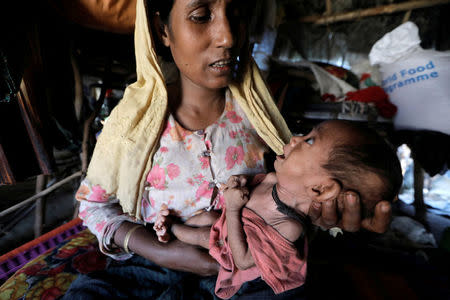 Noor Bejum, 32, a Rohingya refugee holds Rojaika, her 7 months old malnourished daughter as she sits at her shelter in Kutupalong refugees camp in Cox's Bazar, Bangladesh, October 15, 2017. REUTERS/ Zohra Bensemra