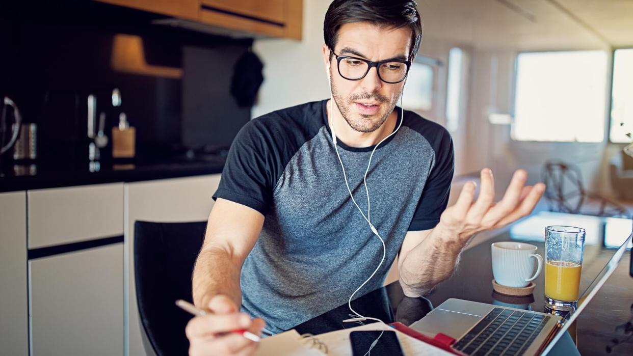 Man is working at home and video conferencing using his laptop.