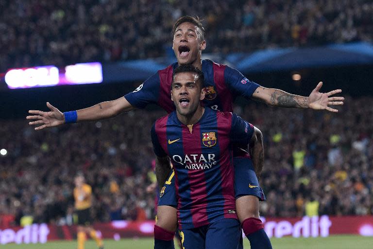 Barcelona's forward Neymar (top) celebrates with his teammate Dani Alves after scoring during the UEFA Champions League quarter-finals second leg football match against Paris Saint-Germain in Barcelona on April 21, 2015