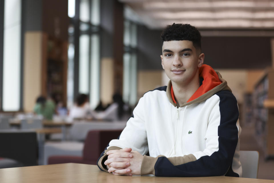 Max Decker, a senior at Lincoln High School, sits for a portrait in the school library where he often worked on writing his college essays, in Portland, Ore., Wednesday, March 20, 2024. (AP Photo/Amanda Loman)