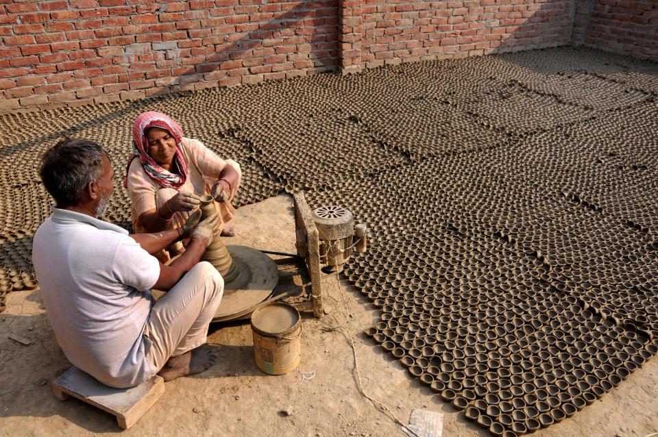 Potters make earthen lamps at their home workshop, ahead of the Diwali festival, in Amritsar, Wednesday, 21 October, 2020. Diwali will be celebrated across the country on 14 November.