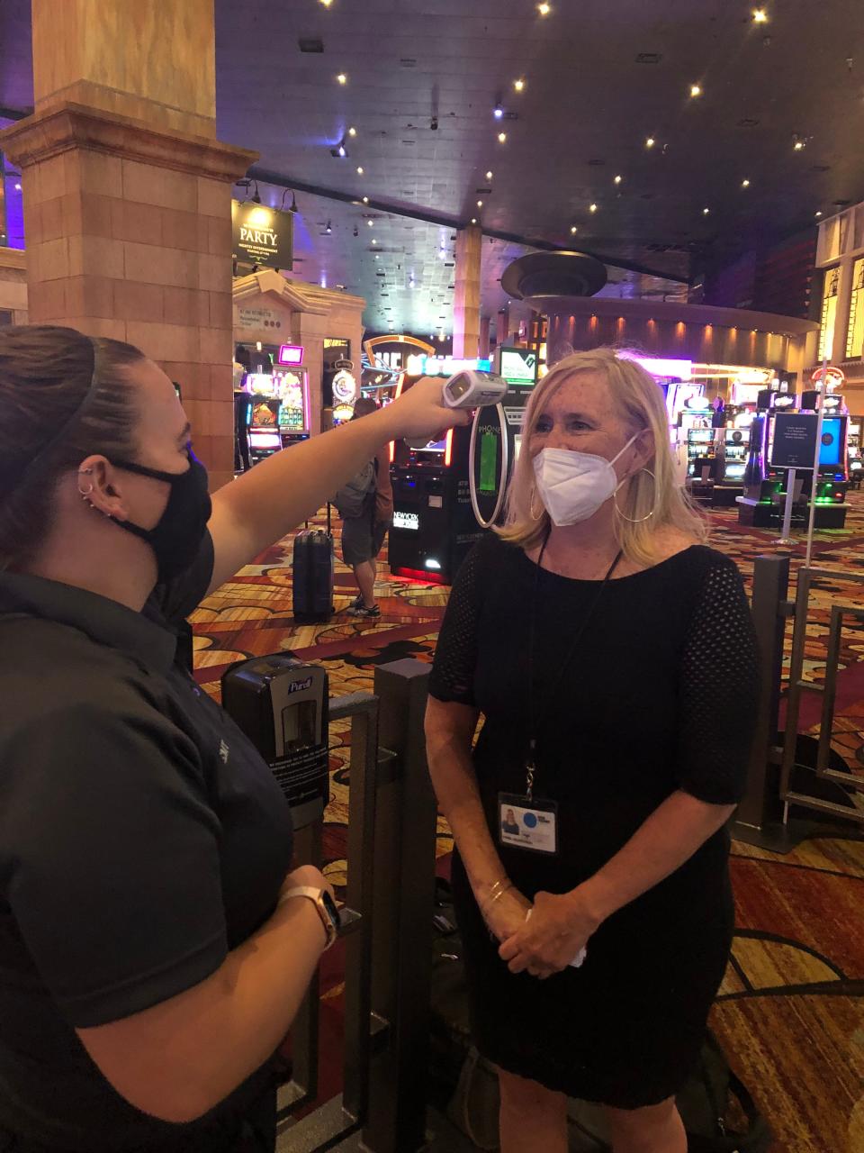 USA TODAY Travel reporter Dawn Gilbertson has her temperature checked before she enters the check-in line at New York-New York Hotel & Casino in Las Vegas during its reopening in early June.