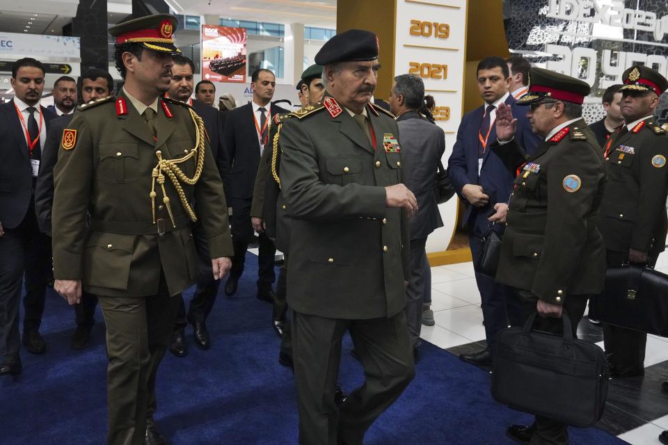 Libya's Khalifa Hifter, the commander of the self-styled Libyan National Army, center, is seen at the International Defense Exhibition and Conference in Abu Dhabi, United Arab Emirates, Monday, Feb. 20, 2023. Just outside of Abu Dhabi's biennial arms fair in a large tent, Russia offered weapons for sale Monday ranging from Kalashnikov assault rifles to missile systems despite facing sanctions from the West over its war on Ukraine. (AP Photo/Jon Gambrell)