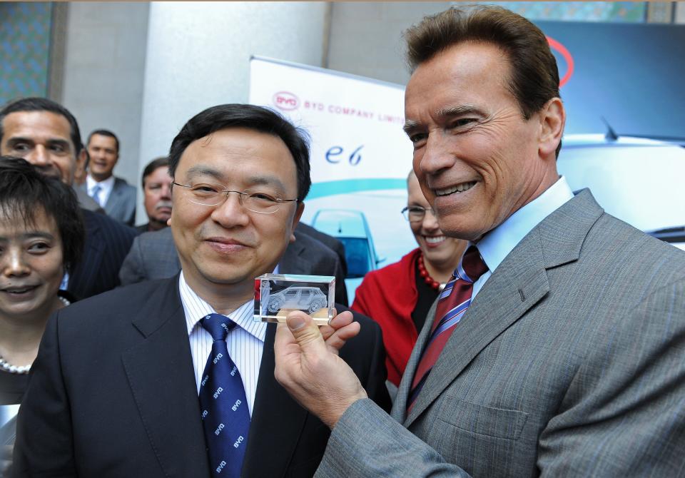 Wang Chuanfu (L), chairman of Chinese alternative-energy auto maker BYD, presents California Governor Arnold Schwarzenegger with a gift at a press conference April 30, 2010 at City Hall in Los Angeles,CA to announce that the Chinese solar energy and automobile firm will locate its US headquarters in Los Angeles, potentially creating hundreds of new jobs. BYD, which stands for Build Your Dreams, is a manufacturer of batteries, solar panels and electric-hybrid vehicles partly financed by billionaire Warren Buffett.