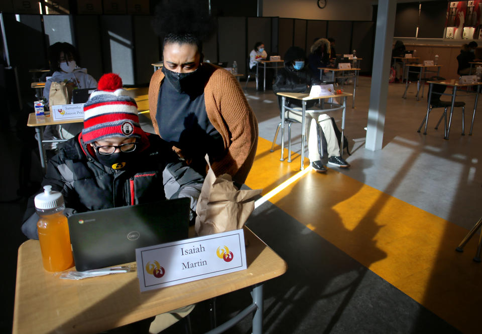 Teaching assistant Renelle Evans helps a student at Boston Prep, a charter middle and high school in Boston on Feb. 2. (Lane Turner/The Boston Globe via Getty Images)