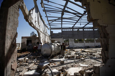 Men inspect the damage inside a medical waste recycling plant which has been recently hit by Saudi-led air strikes on the outskirts of Sanaa, Yemen November 16, 2016. REUTERS/Mohamed al-Sayaghi