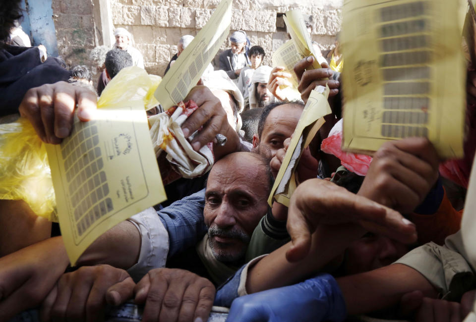 People affected by eight years of war and blockade receive free meals provided by a charitable kitchen in Yemen in 2022.