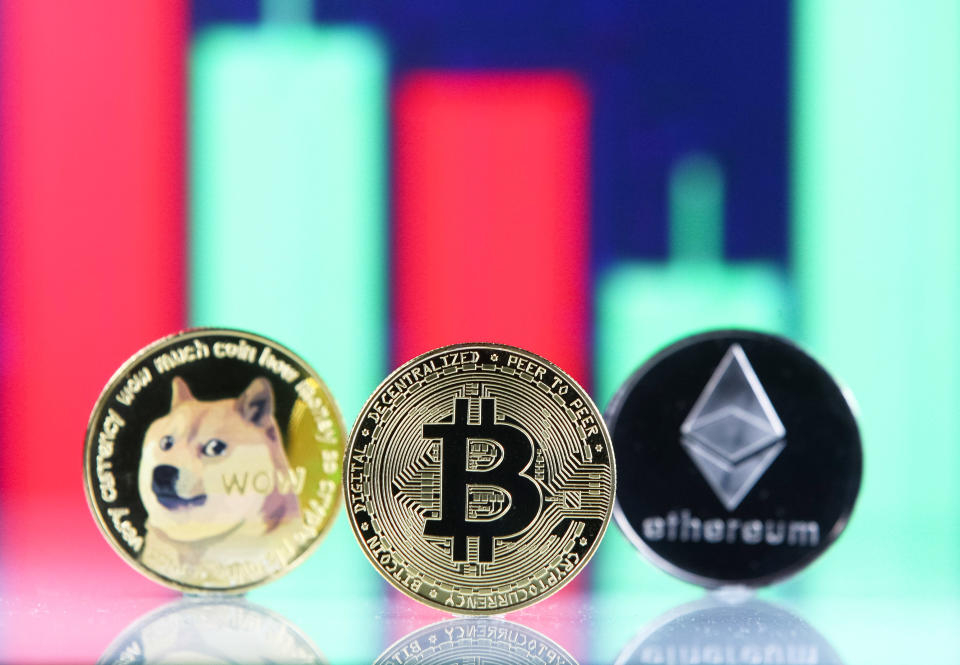 Bitcoin, Dogecoin, Ethereum cryptocurrency coins and a graph are pictured in Kyiv on 08 July, 2021. (Photo by STR/NurPhoto via Getty Images)