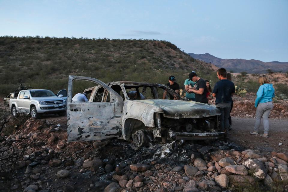 Members of the Lebaron family watch the burned car where part of the nine murdered members of the family were killed and burned during an gunmen ambush on Bavispe, Sonora mountains, Mexico.