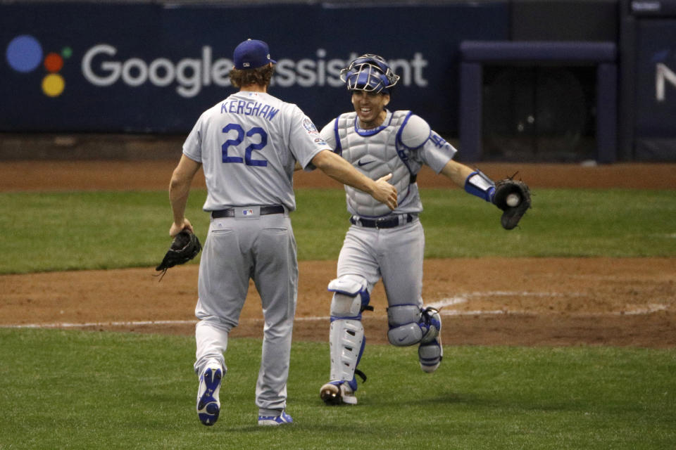 El as Clayton Kershaw, de los Dodgers de Los Ángeles, festeja con su catcher tras concretar la victoria en el séptimo partido de la Serie de Campeonato de la Liga Nacional ante los Cerveceros de Milwaukee, el sábado 20 de octubre de 2018, en Milwaukee. Los Dodgers ganaron 5-1 para llevarse la serie. (AP Foto/Charlie Riedel)