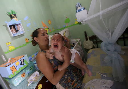 Josemary da Silva, 34, combs the hair of 5-month-old Gilberto after giving him a bath at her house in Algodao de Jandaira, Brazil February 17, 2016. Gilberto is da Silva's fifth child and was born with microcephaly. REUTERS/Ricardo Moraes