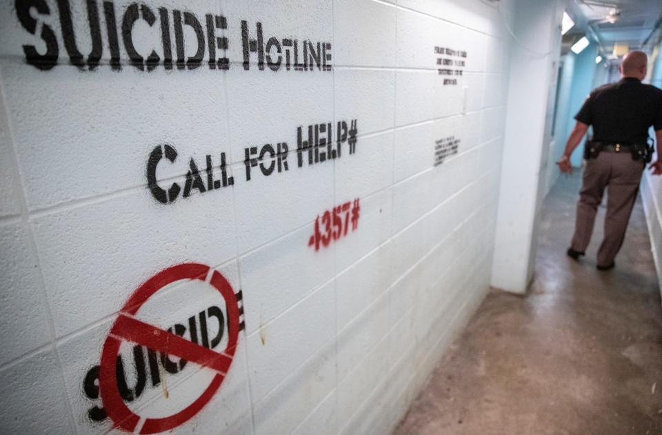 Suicide hotline information is prominently displayed on a wall Thursday, July 15, 2021, at downtown Indianapolis' Marion County Jail 1. Suicide is the leading cause of deaths inside Indiana's county-run jails.