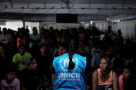 <p>A member of United Nations High Commissioner for Refugees (UNHCR) talks with Venezuelans as they queue in line to receive a vaccine after showing their passports or identity cards at the Pacaraima border control, Roraima state, Brazil, Aug. 8, 2018. (Photo: Nacho Doce/Reuters) </p>