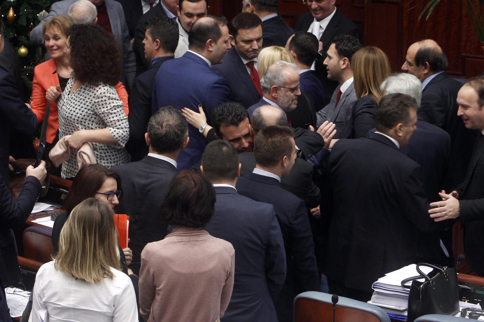 Lawmakers of the ruling coalition led by the social democrats congratulate to each other, after the parliament voted in favor of the constitutional changes, in Macedonian Parliament in the capital Skopje, Friday, Jan. 11, 2019. Macedonia has fulfilled its part of a deal that will pave its way to NATO membership and normalize relations with neighboring Greece, after lawmakers approved constitutional changes that will rename the country North Macedonia. (AP Photo/Boris Grdanoski)