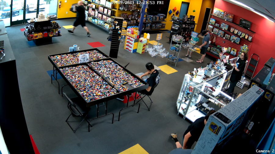 Security footage from July shows a man running out of Bricks and Minifigs after collecting multiple high-valued boxes of Legos. (Edgar Garcia)